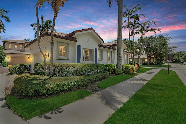 mediterranean / spanish house with a yard and a garage