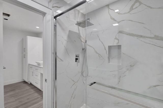 bathroom featuring vanity, an enclosed shower, and hardwood / wood-style floors