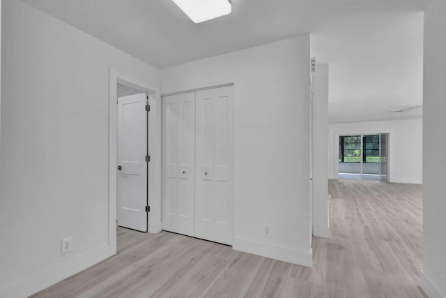 unfurnished bedroom with a closet and light wood-type flooring