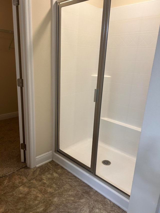 bathroom with a shower with door