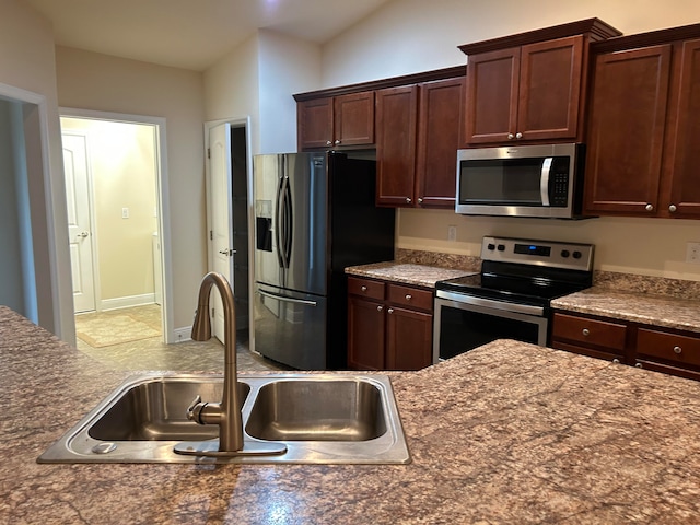 kitchen with lofted ceiling, sink, and stainless steel appliances