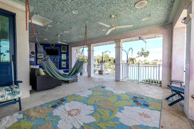 view of patio / terrace featuring a water view and ceiling fan