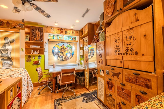 interior space featuring built in desk, ceiling fan, and light hardwood / wood-style floors