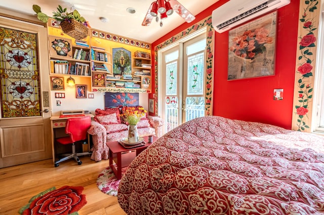 bedroom featuring a wall mounted AC, hardwood / wood-style floors, and access to exterior