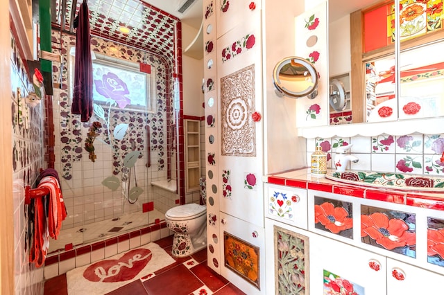 bathroom featuring tile walls, a shower with door, vanity, tile patterned flooring, and toilet