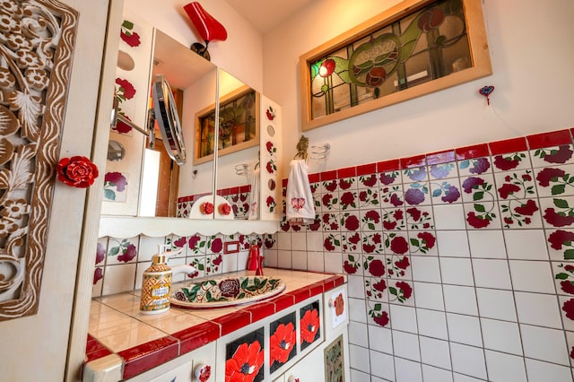 bathroom with vanity and tile walls