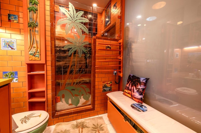 bathroom featuring toilet, vanity, tile patterned floors, and tile walls