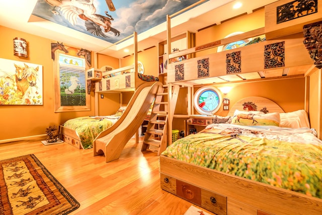 bedroom featuring a tray ceiling and hardwood / wood-style flooring