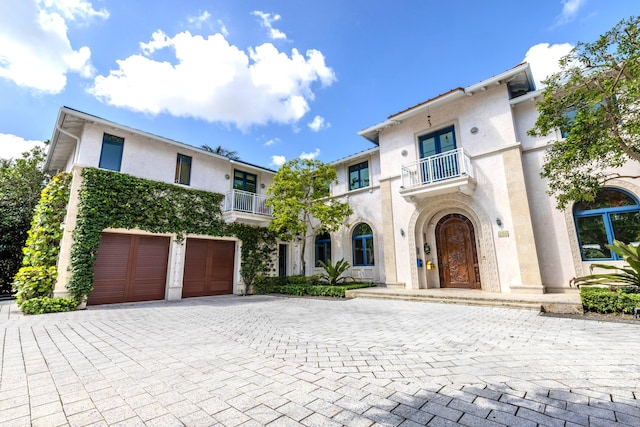 mediterranean / spanish home featuring a balcony and a garage