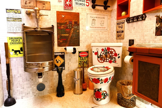 bathroom featuring toilet and backsplash