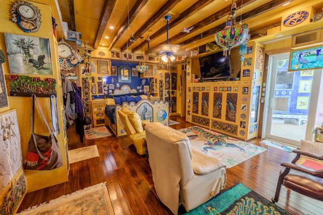 living room with a wealth of natural light, dark hardwood / wood-style flooring, ceiling fan, and beam ceiling