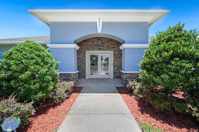 5215 San Benedetto Pl, Fort Pierce, FL 34951 - doorway to property featuring stone siding, french doors, and stucco siding