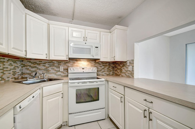 kitchen with decorative backsplash, white cabinets, light tile patterned flooring, sink, and white appliances