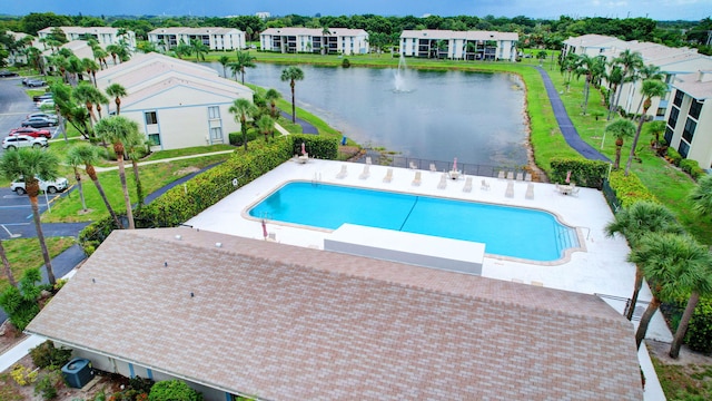 view of pool featuring a patio and a water view