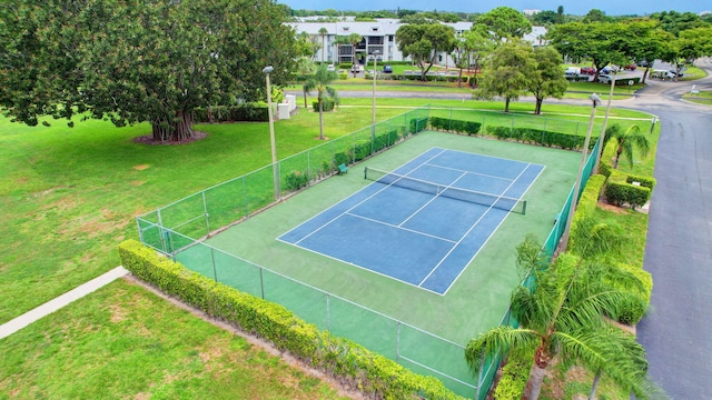 view of sport court with a lawn