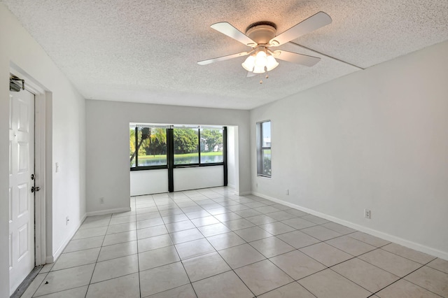 tiled spare room with a textured ceiling and ceiling fan