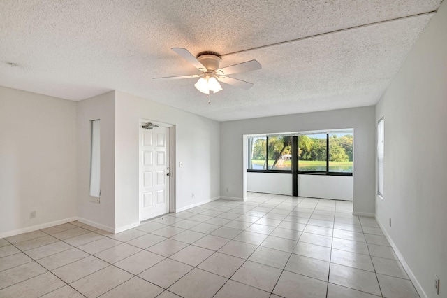 tiled empty room with a textured ceiling and ceiling fan