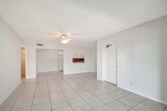 tiled spare room with a textured ceiling and ceiling fan