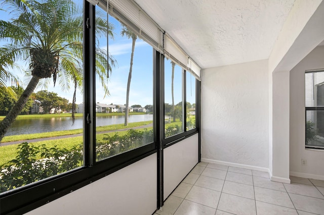 unfurnished sunroom featuring a water view