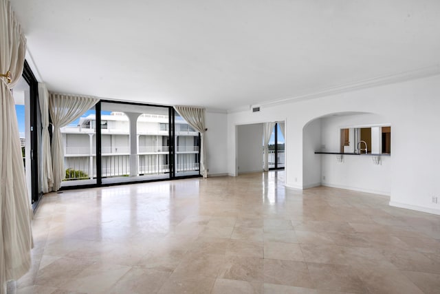 unfurnished room with sink and crown molding