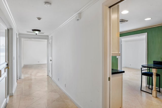 corridor featuring ornamental molding and light tile patterned floors