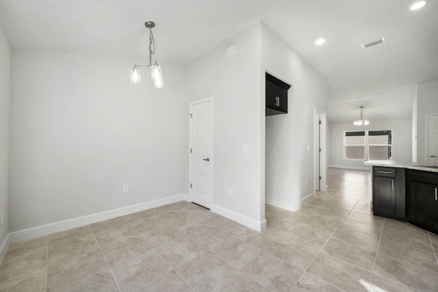 spare room with light tile patterned flooring and an inviting chandelier