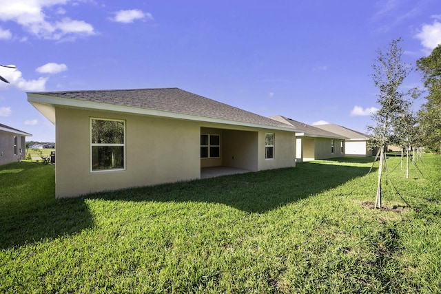 rear view of property with a lawn and a patio