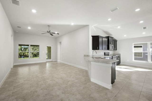 kitchen with light stone countertops, sink, ceiling fan, kitchen peninsula, and appliances with stainless steel finishes