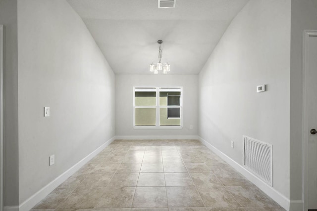 tiled spare room with a chandelier