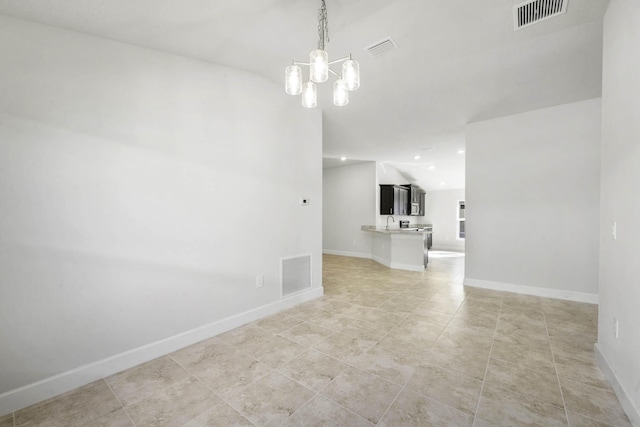 spare room featuring light tile patterned floors, a chandelier, and lofted ceiling