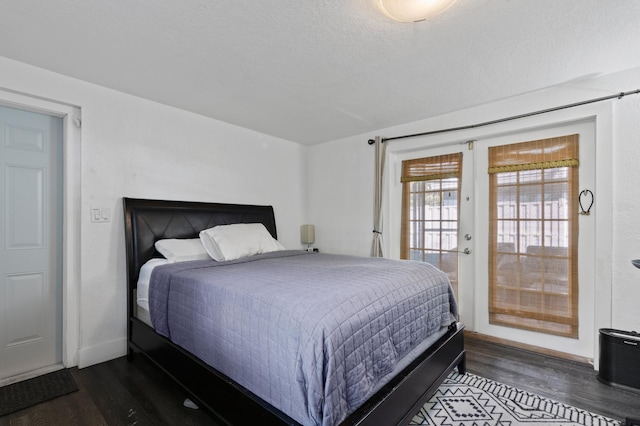 bedroom with french doors, a textured ceiling, access to exterior, and dark wood-type flooring