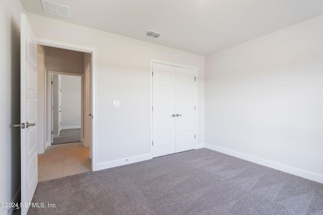 unfurnished bedroom with carpet and a closet