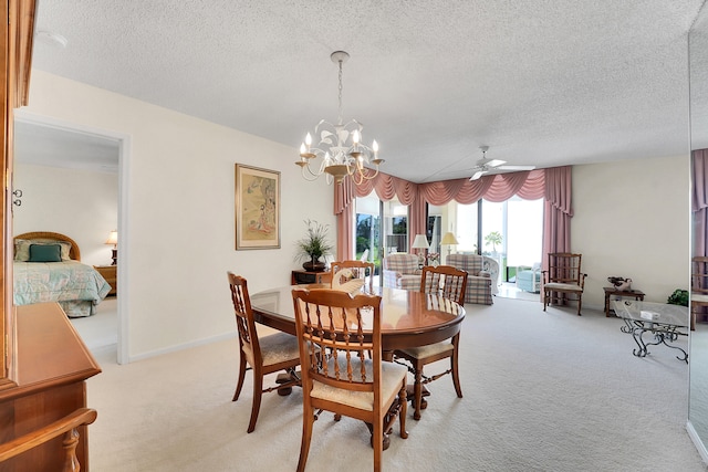 carpeted dining area featuring ceiling fan with notable chandelier and a textured ceiling