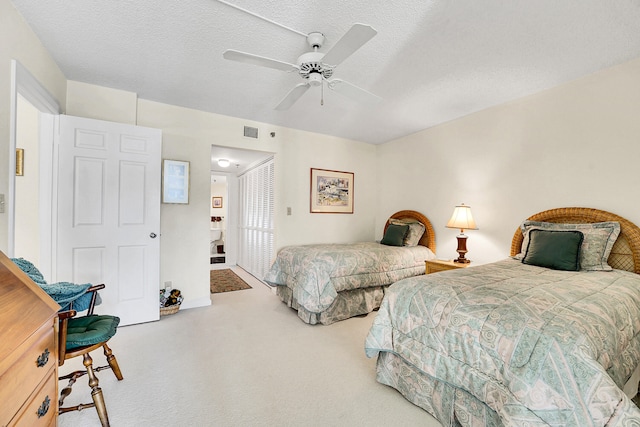 bedroom with ceiling fan, a closet, carpet floors, and a textured ceiling