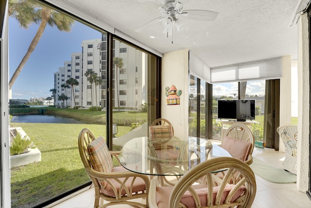 sunroom with a water view and ceiling fan