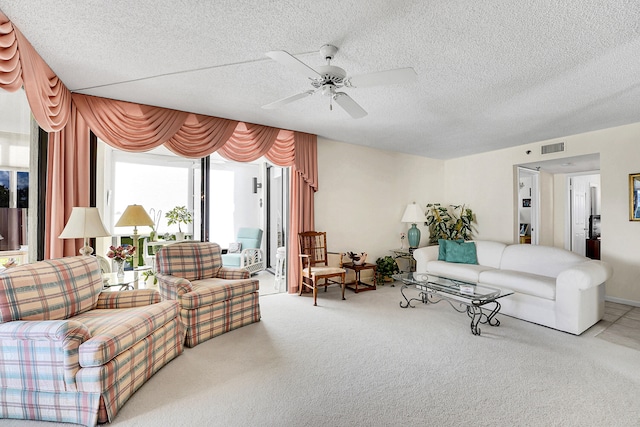 living room featuring carpet, a textured ceiling, and ceiling fan