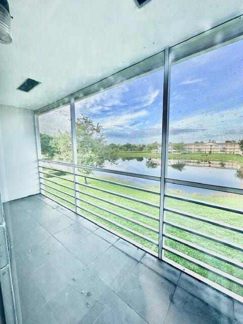 unfurnished sunroom featuring a water view