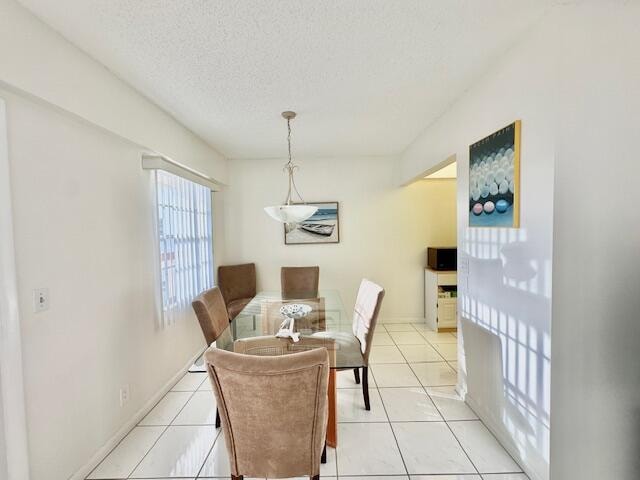 dining area with a textured ceiling and light tile patterned flooring