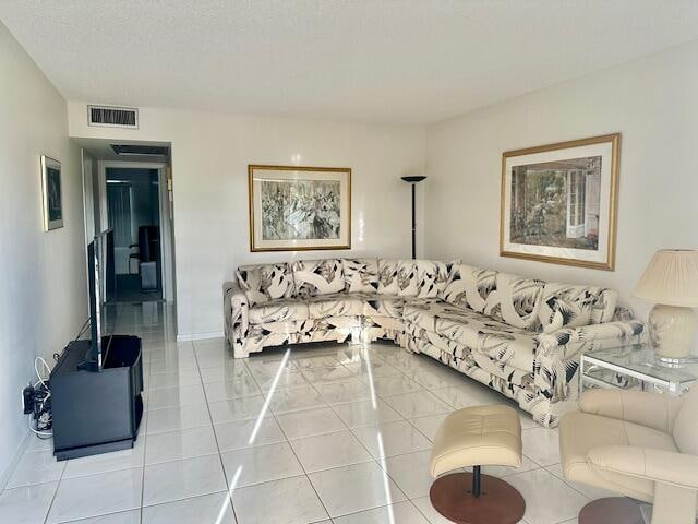 living room with a textured ceiling and light tile patterned floors