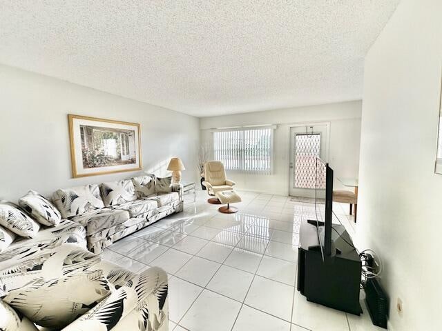 living room with a textured ceiling and light tile patterned floors