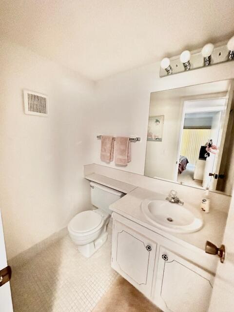 bathroom with vanity, toilet, and tile patterned flooring