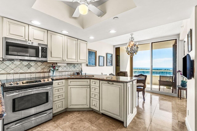 kitchen featuring a sink, decorative backsplash, a peninsula, appliances with stainless steel finishes, and recessed lighting
