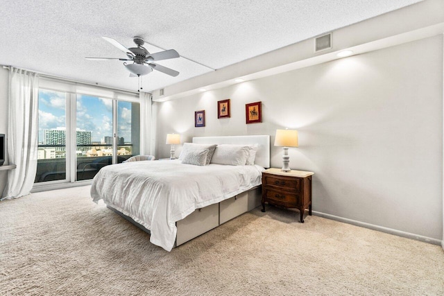 bedroom with ceiling fan, carpet, a textured ceiling, and access to exterior