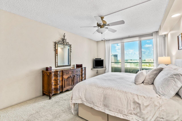 carpeted bedroom with ceiling fan, a textured ceiling, and access to exterior