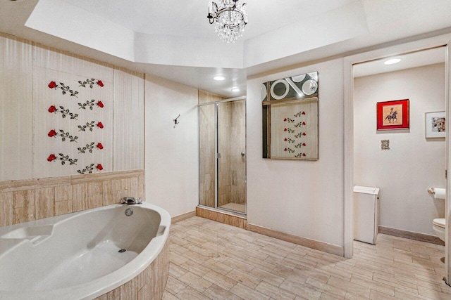 bathroom with toilet, a raised ceiling, separate shower and tub, and hardwood / wood-style floors