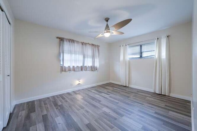 unfurnished bedroom featuring a closet, hardwood / wood-style floors, and ceiling fan