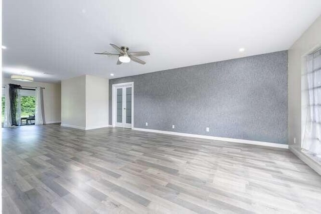 empty room with light hardwood / wood-style floors, french doors, and ceiling fan