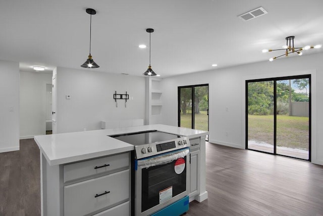 kitchen with a center island, stainless steel electric stove, light countertops, hanging light fixtures, and visible vents