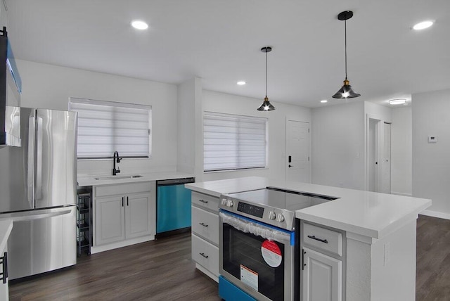 kitchen featuring decorative light fixtures, stainless steel appliances, light countertops, white cabinets, and a kitchen island