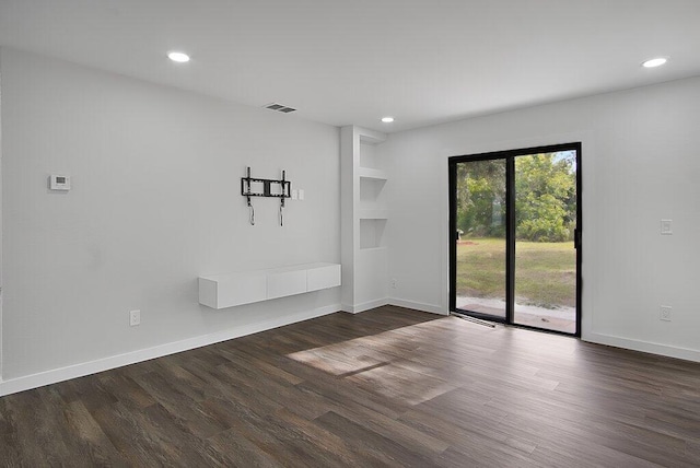 spare room featuring dark wood-style floors, baseboards, visible vents, and recessed lighting